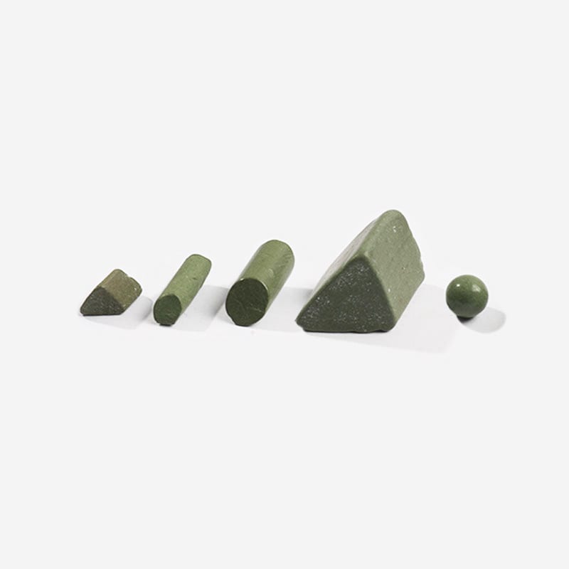 The image shows a set of four green stones on a white surface, which appear to be a stone block and a stone ball. The stones are arranged in a triangular formation, with the stone block in the center 
