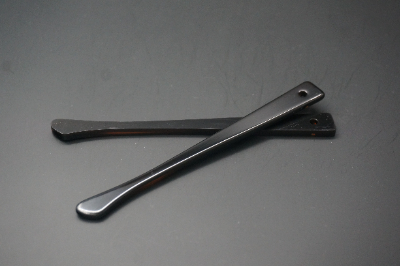 Polished black acetate eyeglass temples showing edge and hinge details