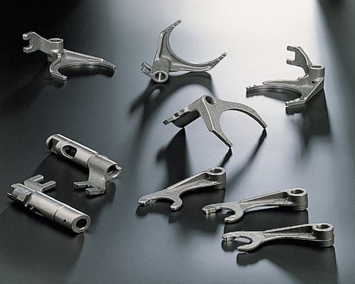 The image shows a black surface with a bunch of metal parts sitting on top of it. The parts appear to be metal objects, and there is a watermark in the bottom right corner of the image.